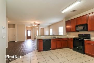Baytown house for rent - A kitchen with wooden cabinets and black appliances.