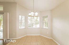Lakeland house for rent - an empty dining room with three windows and a tiled floor