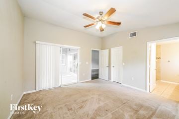 Lakeland house for rent - a living room with carpet and a ceiling fan