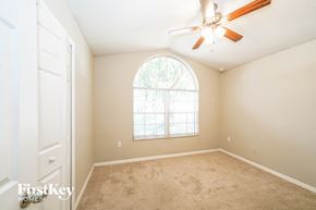 Lakeland house for rent - an empty bedroom with a large window and a ceiling fan