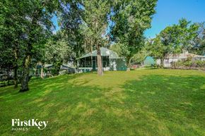 Lakeland house for rent - a green house sitting in the middle of a grass field
