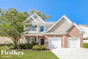 Braselton house for rent - A house with a brick facade and a white garage door is for sale.