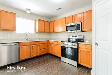 Avon house for rent - A kitchen with wooden cabinets and a stainless steel refrigerator.