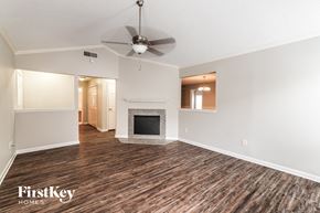 Tampa house for rent - a living room with a fireplace and a ceiling fan