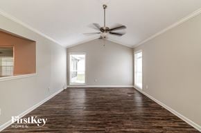 Tampa house for rent - an empty living room with a ceiling fan and a window