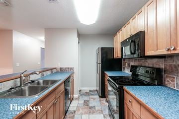 Tampa house for rent - a kitchen with black appliances and blue counter tops