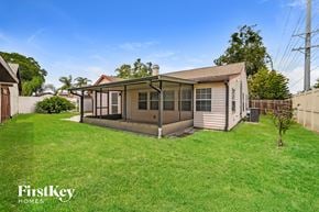 Tampa house for rent - a backyard with a small house and a yard with grass