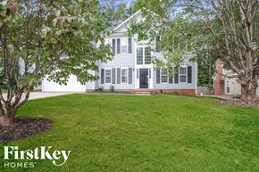 Charlotte house for rent - a white house with a green lawn and trees