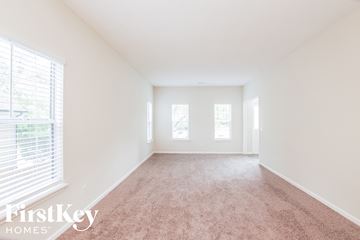 Charlotte house for rent - a spacious living room with carpet and three windows