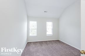 Charlotte house for rent - a bedroom with white walls and carpet and two windows