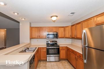 Cordova house for rent - a kitchen with wooden cabinets and stainless steel appliances