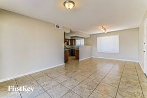 Peoria house for rent - an empty living room with a kitchen in the background