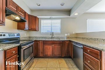 Peoria house for rent - a kitchen with wooden cabinets and stainless steel appliances