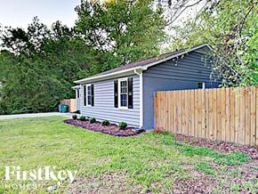 Charlotte house for rent - a small blue house with a wooden fence in front of it