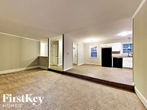 Charlotte house for rent - an empty living room with a kitchen in the background
