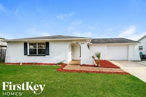 Port Richey house for rent - a white house with a yard and grass