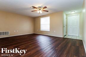 Port Richey house for rent - an empty living room with hardwood flooring and a ceiling fan