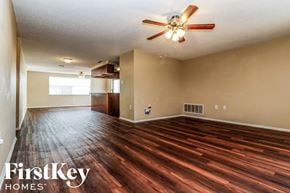 Port Richey house for rent - an empty living room with wood flooring and a ceiling fan