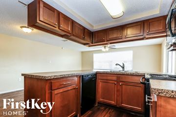 Port Richey house for rent - a kitchen with wooden cabinets and a black dishwasher