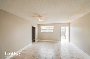 Hollywood house for rent - an empty living room with a ceiling fan and tiled floors