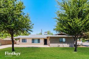 Phoenix house for rent - A house with a lawn and trees in front of it.