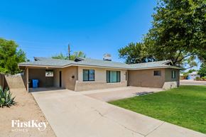 Phoenix house for rent - A house with a brown roof and a blue trash bin in front.