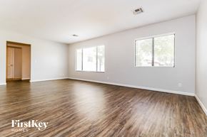 Phoenix house for rent - A room with wooden floors and two windows.