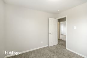 Richmond house for rent - a bedroom with white walls and carpet and a door to a hallway
