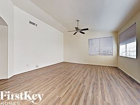 Mesa house for rent - an empty living room with wood floors and a ceiling fan