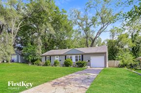 Kansas City house for rent - a blue house with a lawn and trees