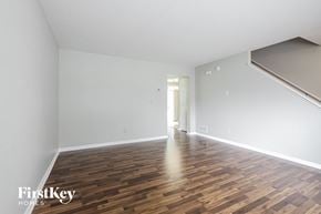 Indianapolis house for rent - A room with wooden flooring and a staircase in the background.