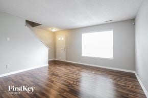 Indianapolis house for rent - A room with wooden floors and a window with a white frame.