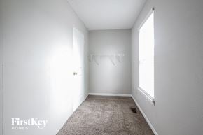 Indianapolis house for rent - A white bedroom with a carpet floor and a window.