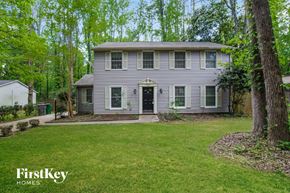 Charlotte house for rent - a gray house with a green lawn and trees