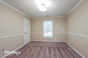 Charlotte house for rent - an empty dining room with carpet and a white door