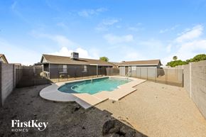 Peoria house for rent - a backyard with a pool and a fence and a house