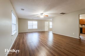 Magnolia house for rent - A spacious room with wooden floors and a ceiling fan.