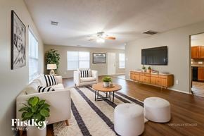 Magnolia house for rent - A living room with a white couch, a coffee table, and a television.