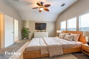 Magnolia house for rent - A bedroom with a large bed and a ceiling fan.