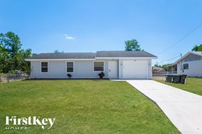 North Port house for rent - A white house with a grey roof and a white garage door is shown in the image.