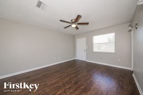 North Port house for rent - A room with a ceiling fan and wooden flooring.