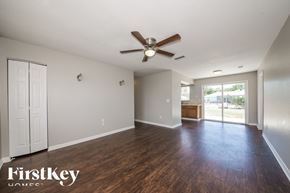North Port house for rent - A spacious room with a ceiling fan and wooden flooring.