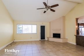Houston house for rent - A spacious room with a fireplace and a ceiling fan.