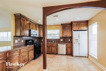 Houston house for rent - A kitchen with wooden cabinets and a white refrigerator.