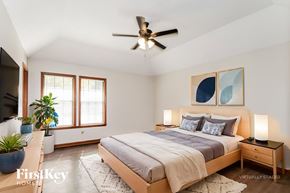 Memphis house for rent - A bedroom with a bed, a ceiling fan, and a painting on the wall.
