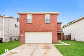 Cypress house for rent - a brick house with a white garage door