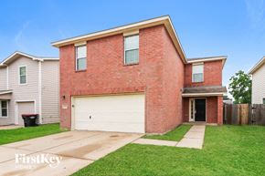 Cypress house for rent - a brick house with a white garage door and a lawn