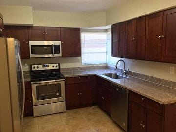 Hollywood house for rent - A kitchen with brown cabinets and stainless steel appliances.