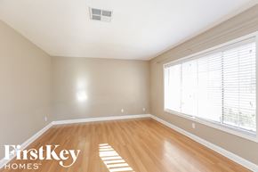 Peoria house for rent - A room with wooden floors and a window with blinds.