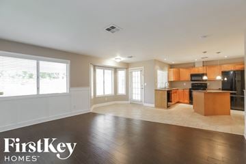 Peoria house for rent - A spacious kitchen and living room with wooden floors and a large island.